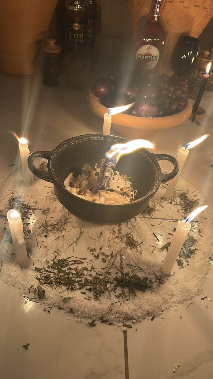 Caldeirão com ervas e círculo de sal e velas